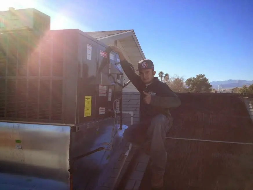 HVAC technician performing HVAC Inspection on a rooftop unit in Dexter